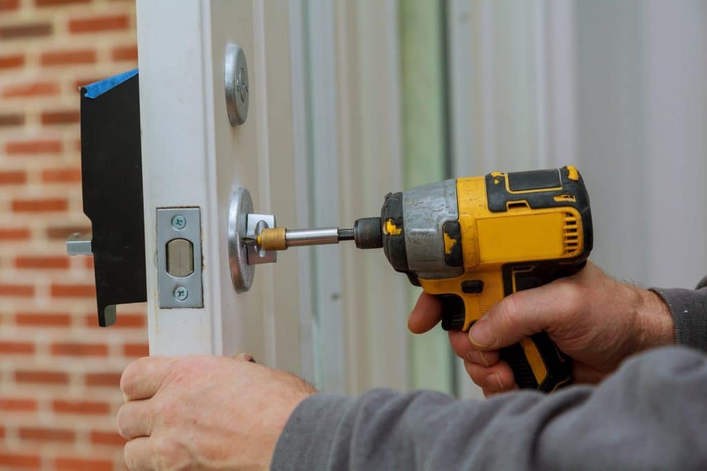 a person using a screwdriver to fix a door