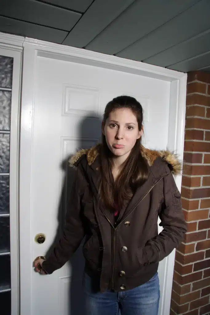 a woman standing in front of a white door