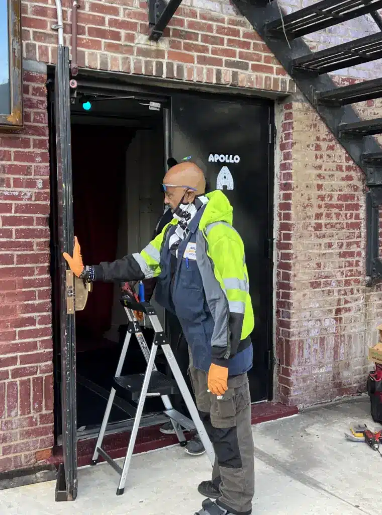 a man wearing a mask and gloves standing on a ladder