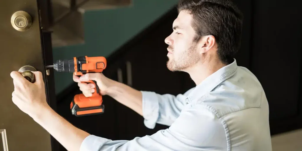 a man holding an orange and black drill