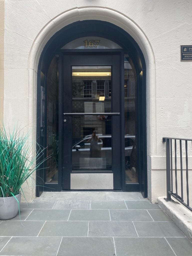 Modern arched glass entrance door at a residential apartment building in NYC