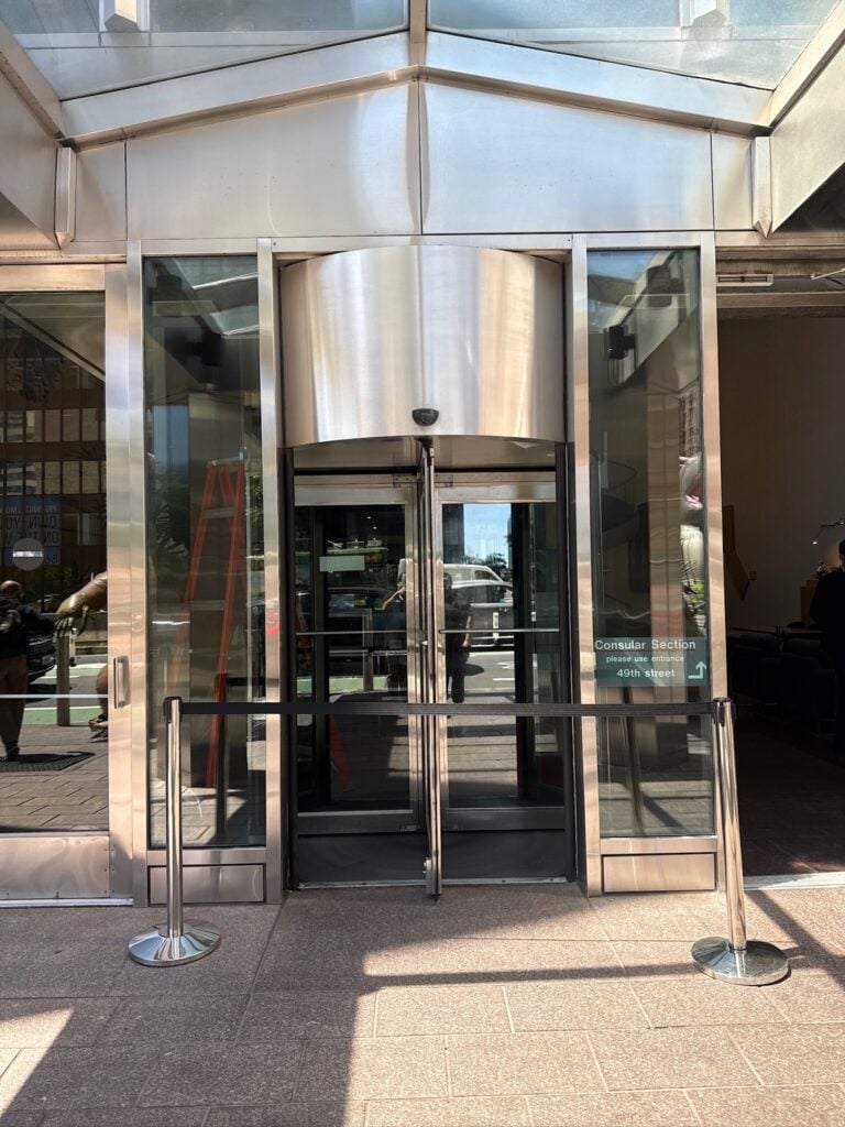 Large stainless steel revolving door at a commercial office building entrance in NYC