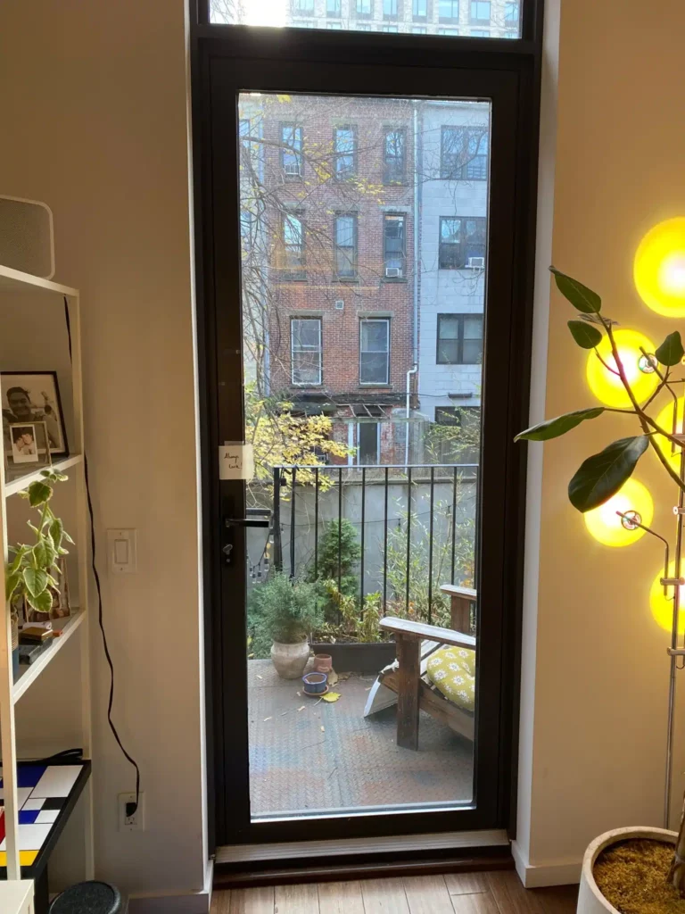 Residential glass balcony door with weatherstripping and frame seal in a New York City apartment