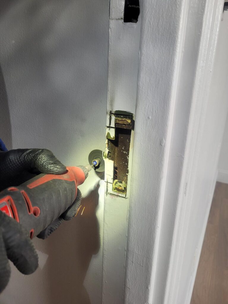 a person using a screwdriver to fix a door