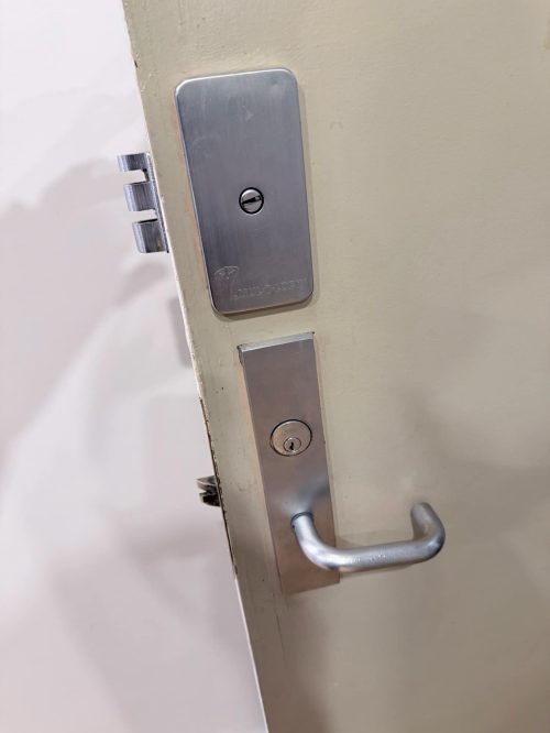 Commercial door lock hardware being repaired - lever handle and deadbolt