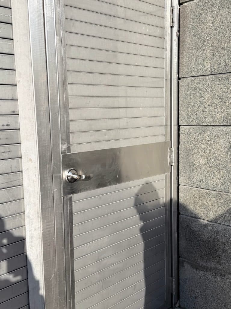 Metal security door with lever handle at a New York City building