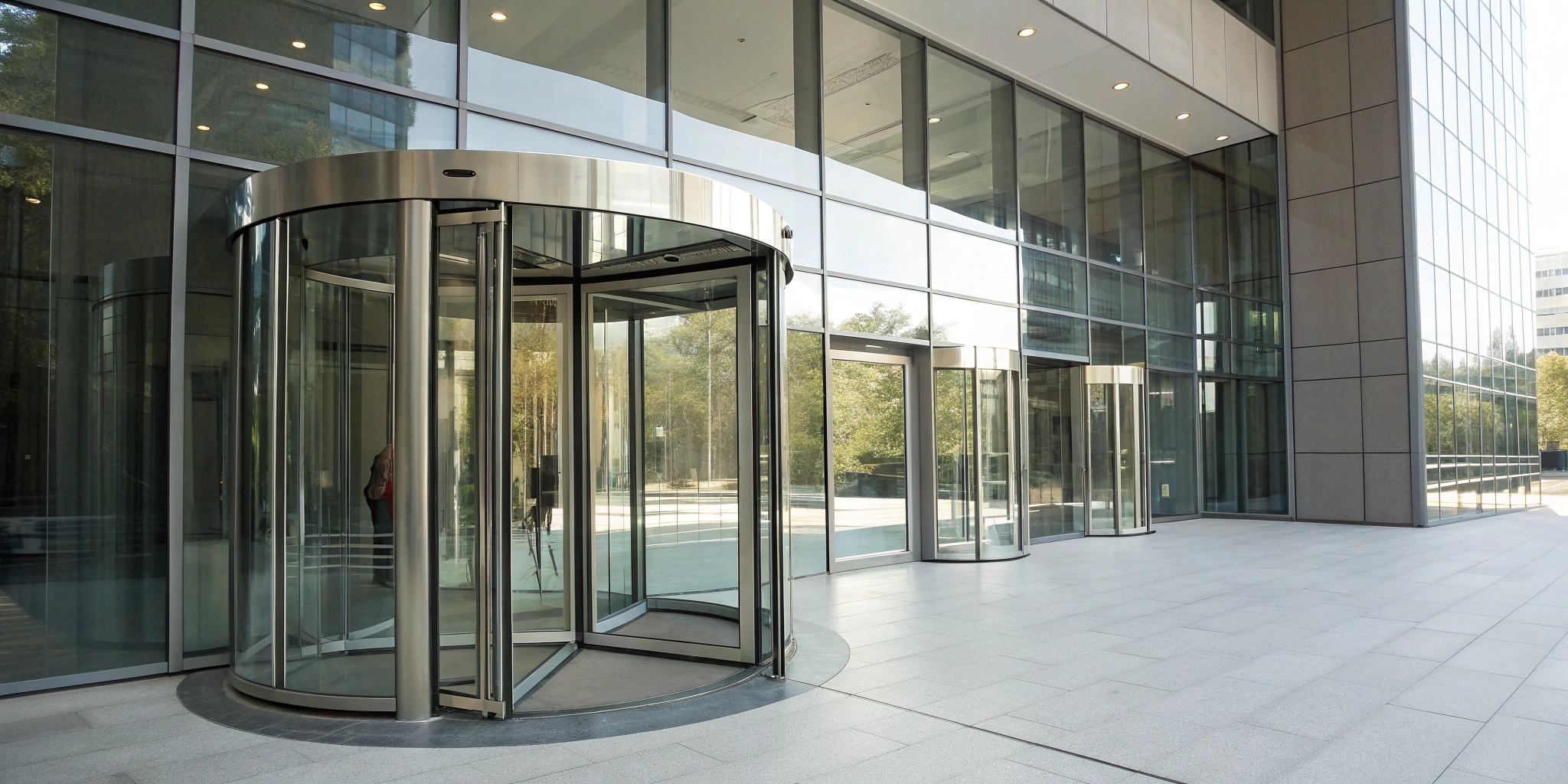 Modern glass revolving doors at the entrance of a commercial building.
